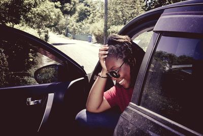 Smiling young woman sitting in car