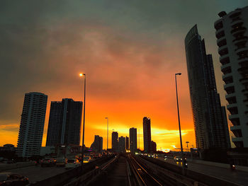 City street and buildings against sky during sunset