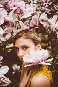 Portrait of young woman amidst pink flowers