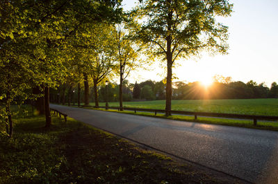 Scenic view of grassy field against sky at sunset