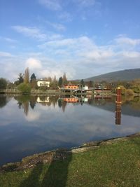 Scenic view of lake by buildings against sky