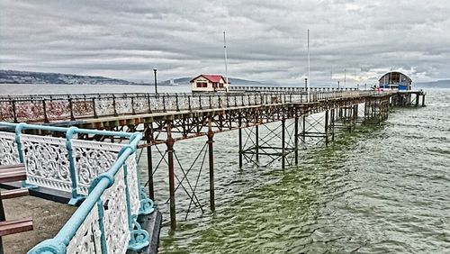 View of pier on sea against cloudy sky