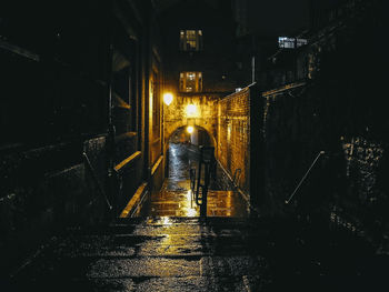 People on street amidst illuminated buildings at night