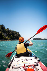 Woman on boat in sea against clear sky