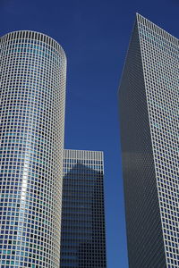 Low angle view of modern buildings against clear blue sky