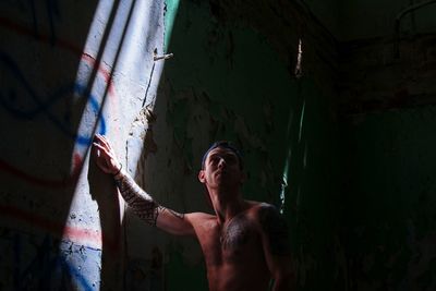 Full length of shirtless man standing in corridor