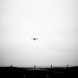 Low angle view of airplane over runway against clear sky