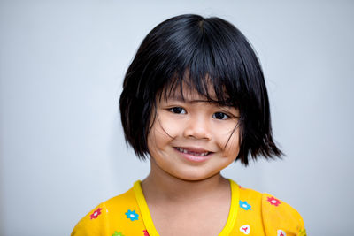 Portrait of smiling boy against white background