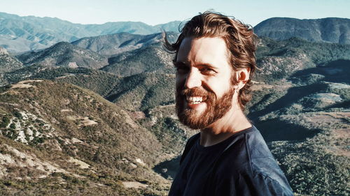 Portrait of young man against mountains