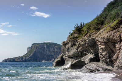 Rock formations by sea against sky