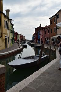 Canal amidst buildings in city against sky