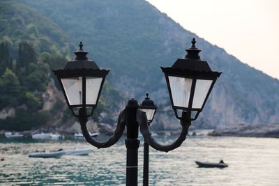 Street light by river against mountains