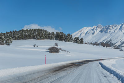 Scenic view of snowcapped mountains against clear blue sky