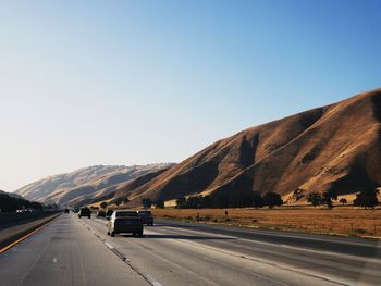 Road by mountain against clear sky