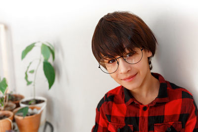 Portrait of smiling woman against wall