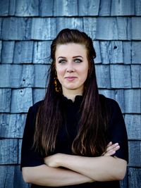 Portrait of beautiful young woman against roof tiles