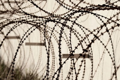 Close-up of barbed wire fence against sky