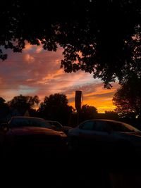 Cars parked on road at sunset