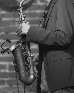 Midsection of man playing saxophone