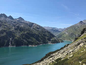 Scenic view of lake by mountains against sky