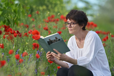 Full length of woman holding flowering plants