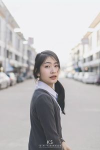 Portrait of woman standing on road against clear sky