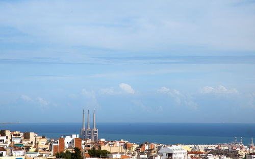 Buildings by sea against sky