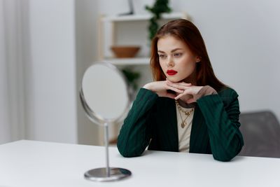 Portrait of young woman drinking water at home