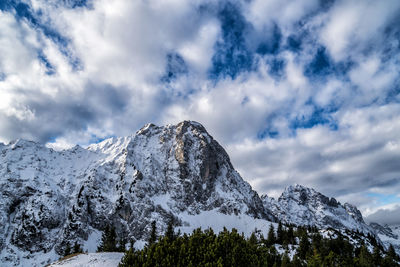 Low angle view of snowcapped mountains against sky