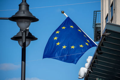 Low angle view of flags against blue sky