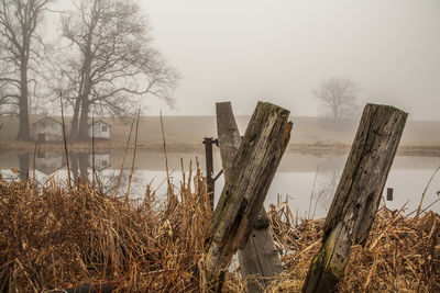 Wooden posts on field against sky