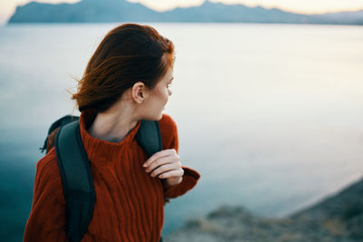 Young woman standing at sea shore