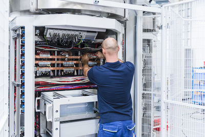 Man using voltmeter in modern factory