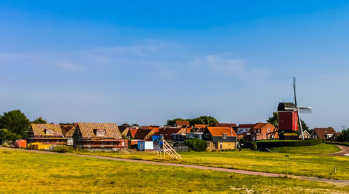 Houses on field against sky