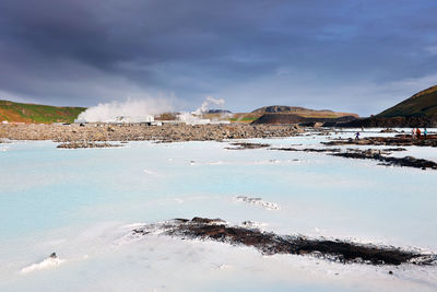 Scenic view of sea and snowcapped mountains against sky