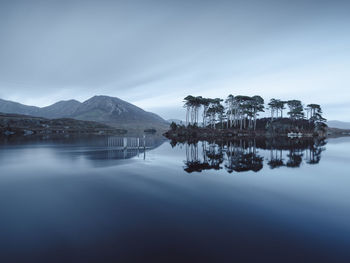 Scenic view of lake by mountains against sky