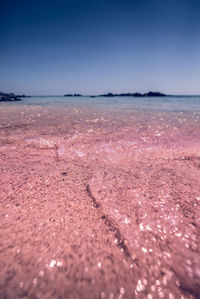 Surface level of beach against clear sky