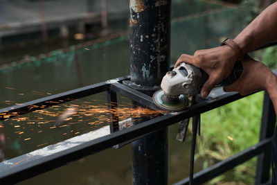 Cropped hands of person working on metal