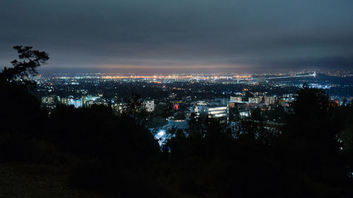 High angle view of illuminated buildings against sky at night