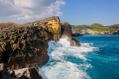 Rock formations in sea against sky