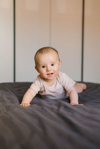 Cute baby lies on his tummy resting on his wrists.