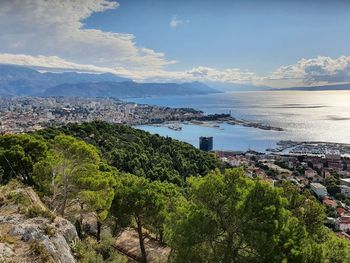 High angle view of city by sea against sky