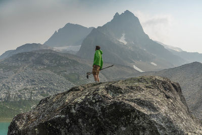 Jasper national park, alberta, canada. man on rock by mountains against sky.