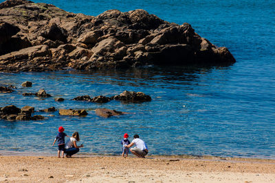 People on rocks by sea