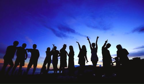 Silhouette people against blue sky