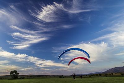 Umbrella flying over field against sky