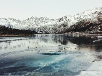 Scenic view of frozen lake by snowcapped mountains