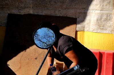 Reflection of man photographing mirror