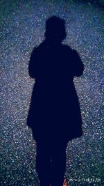 Rear view of silhouette man standing against multi colored shadow