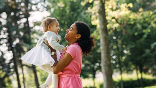 Side view of mother and daughter on tree